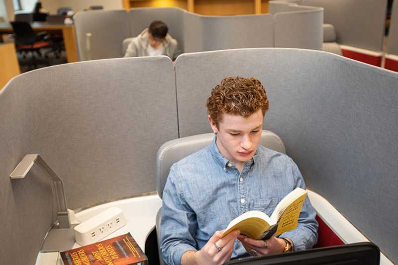 Photo of a Case Western Reserve University student reading in a cubicle
