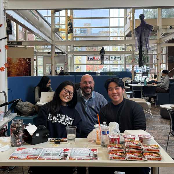 Three people posing at a table in Thwing Student Center.